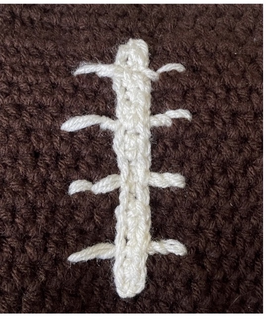 Football stitching detail on the crochet Football Fan Goose sweater