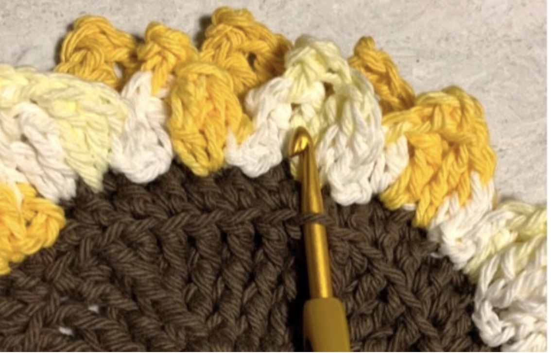 Finished front round of crochet sunflower petals on the Kitchen Sunflowers Trivet