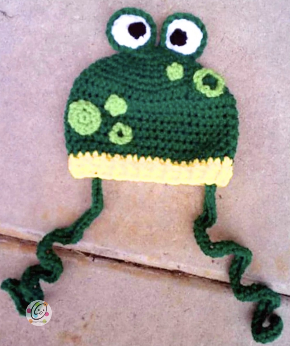 Ribbitz the Frog crochet hat beside the printed pattern